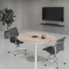 Modern oak finish round meeting table in a bright corporate office conference room