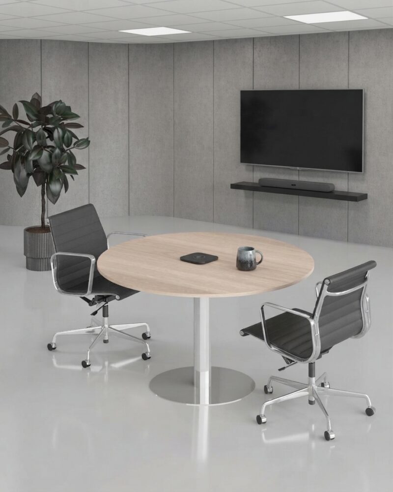 Modern oak finish round meeting table in a bright corporate office conference room