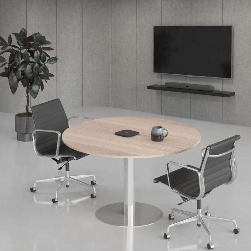Modern oak finish round meeting table in a bright corporate office conference room