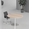 Modern oak finish round meeting table in a bright corporate office conference room